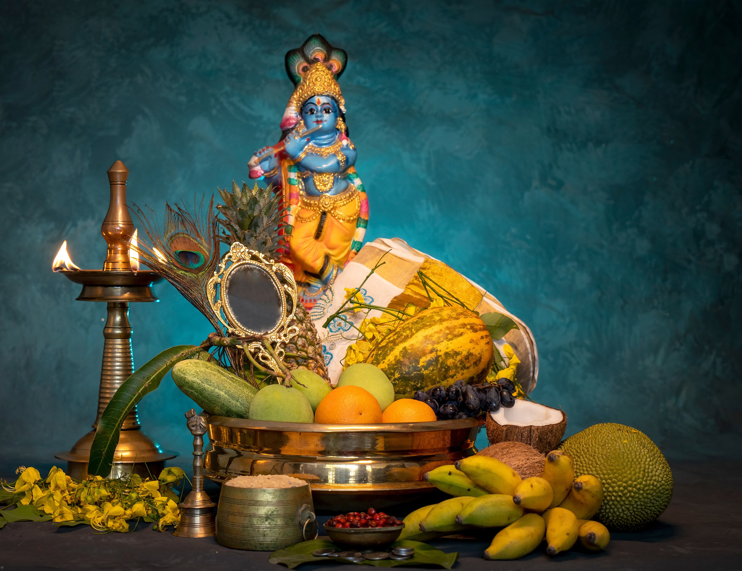 Traditional Krishna Janmashtami setup with Lord Krishna idol, fruits, lamp, peacock feathers, and festive decorations for home celebration.